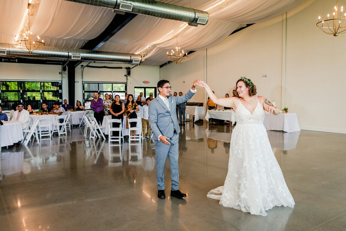 A couple's first dance as guests look on